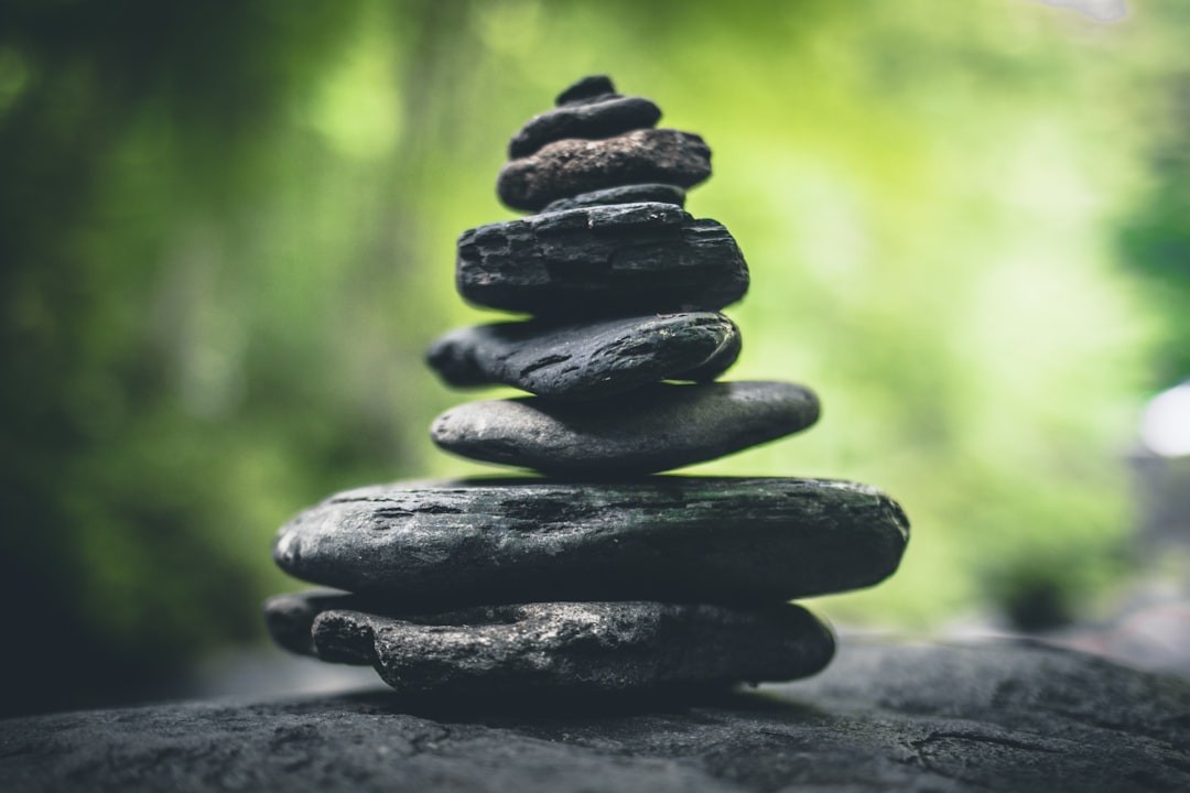 Close-up of a carefully balanced stack of variously sized smooth stones on a blurred natural background.